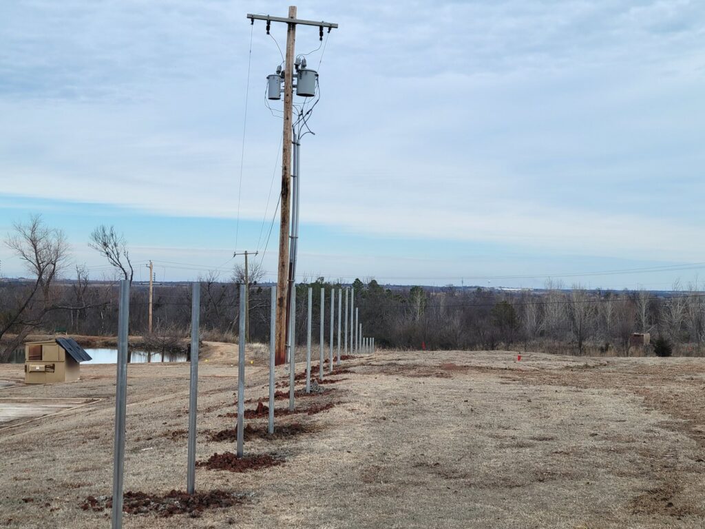 Fence posts installed in a large open field by Veteran Fence Company LLC in Shawnee, OK.
