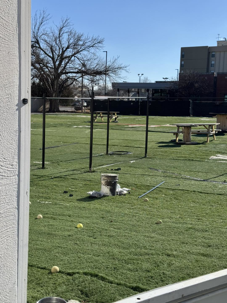Fence posts being installed on an artificial turf field, showing work in progress by Just Handy Fence and Stain LLC in Tulsa, OK.