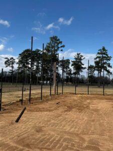 Multiple fence posts installed in the ground for a new fence project by Smithfield Fence in Crowder, MS.