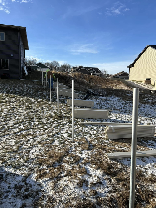 Fence posts installed on a snowy, sloped backyard for a new fence installation by Flash Fence in Phenix City, AL.