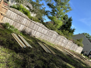 Fence replacement in progress with new lumber on the ground at a job site by Progressive Fences LLC in Dunn, NC.