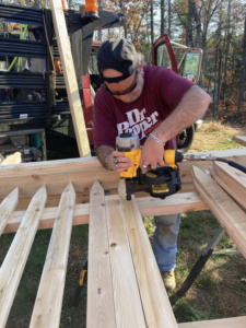 A fencing contractor assembling wooden fence pickets with a nail gun, showcasing work by Profence in Leander, TX.
