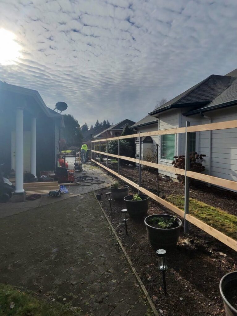 A fencing contractor installing a new wood fence, showing posts and rails, by RPB Fence in Salem, OR