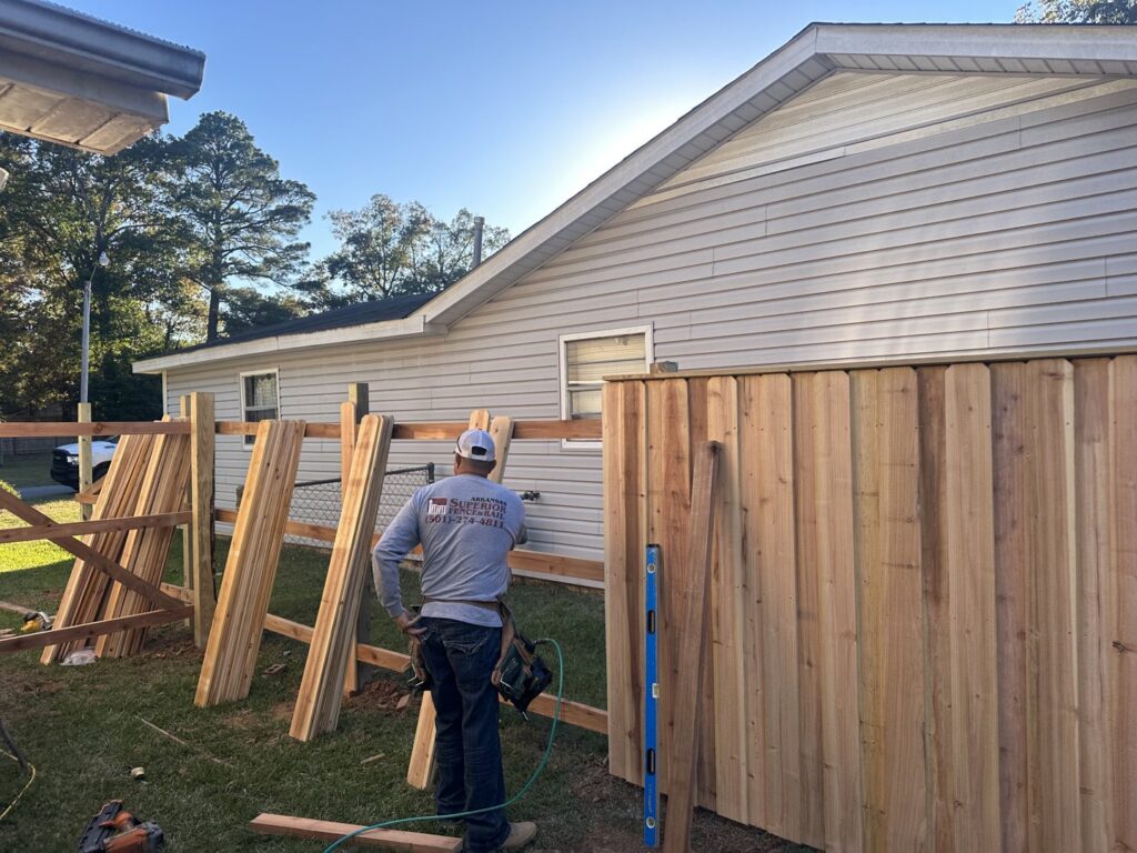 A fencing contractor installing a new wood privacy fence for Superior Fence and Rail of Little Rock, AR
