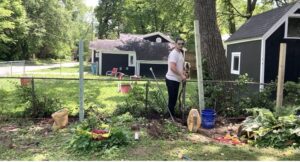 A fencing contractor from Axiom Fence LLC installing a new wood fence post in Springfield, MO.