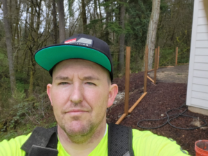 A fencing contractor on a job site installing new fence posts for Jones NW Fence Company in Vancouver, WA.