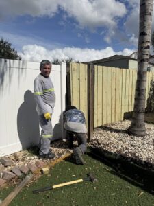 Fencing contractors from Santis Fence & Home Service installing a wood fence section in Tampa Heights, FL