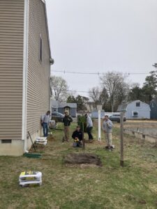 A fencing crew from MAC Fencing LLC installing fence posts in a residential yard in Toms River, NJ