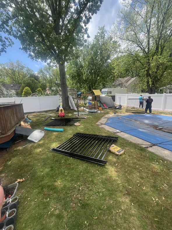 A fencing crew working on a new white vinyl and black metal fence installation for Fence Pros LLC in Medford, OR.