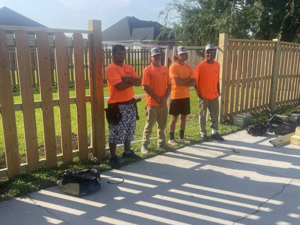 The Southern Fencing, LLC crew standing proudly in front of a newly installed wood fence in Houma, LA.