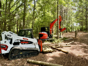 Heavy equipment and wooden fence posts ready for installation by Smith Land and Farm in Mansfield, GA
