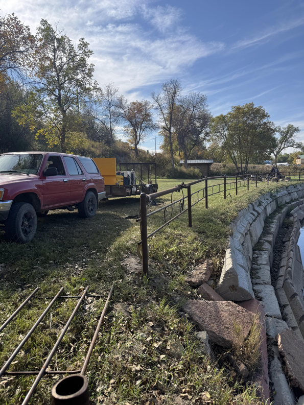 Fencing equipment, truck, and trailer at a job site by Deer Creek Ag Services in Ranchester, WY.