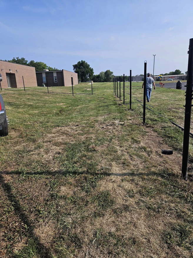 Fence posts installed in the ground, indicating a fencing installation project in progress by Atchison Fence in Effingham, KS.