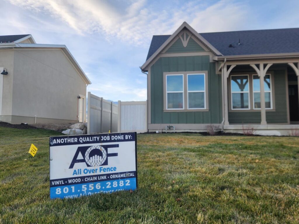 A quality fencing job completed by All Over Fence Idaho, with a promotional sign in the foreground in Jerome, ID