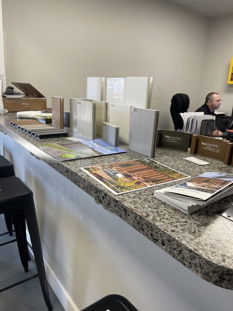 Fencing material samples and brochures displayed on a counter at Julien Affordable Fencing LLC in Jacksonville, FL