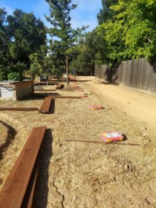 Fencing materials, including wood planks and concrete bags, laid out on a job site for installation by Horizon Fence & Custom Gates, Inc. in Orangevale, CA.