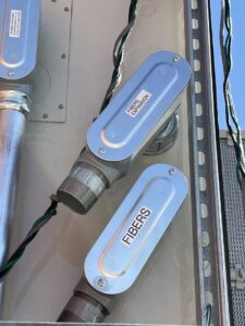 Close-up of fiber optic conduit installation with 'FIBERS EXPANSION' labels by Electrician Near Me in Broken Arrow, OK.