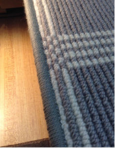 Close-up of a professionally finished carpet edge with binding by Carpet Ends in West Springfield, MA.
