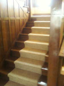A beautifully finished carpet stair runner installed by Karsten Floors, a carpet contractor in Kearney, NE.