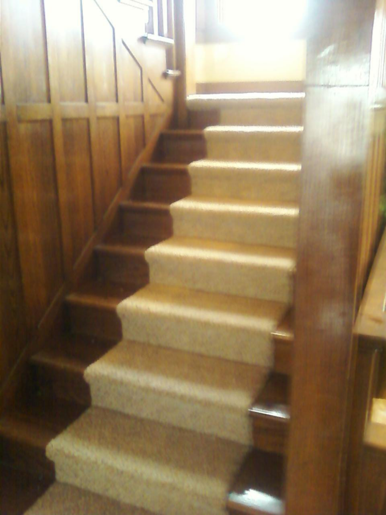 A beautifully finished carpet stair runner installed by Karsten Floors, a carpet contractor in Kearney, NE.