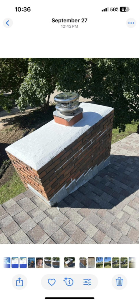 A newly repaired and installed chimney with a metal cap on a residential roof by Harry's Quality Chimney Services in Kansas City, MO