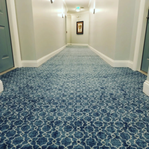 A close-up view of newly installed blue patterned carpet in a commercial hallway by Yankees Carpet Inc in Baltimore, MD