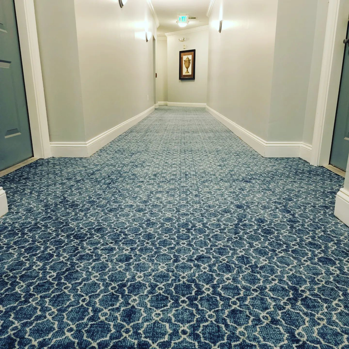 A close-up view of newly installed blue patterned carpet in a commercial hallway by Yankees Carpet Inc in Baltimore, MD