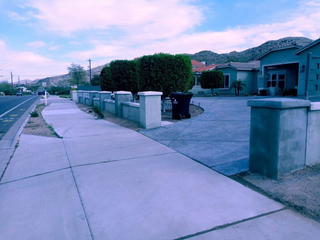 A finished concrete block fence along a sidewalk, built by Arce Masonry LLC in Glendale, AZ
