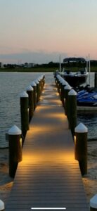 A beautifully lit dock at dusk with installed pathway lighting by RTF Electric LLC in Toms River, NJ.