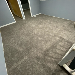 A room with a finished grey carpet installation, demonstrating expert work by HK Carpet Doctors in Sterling Heights, MI