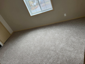 Finished grey carpet in a room with a window, installed by La 23 floors an more in Janesville, WI.
