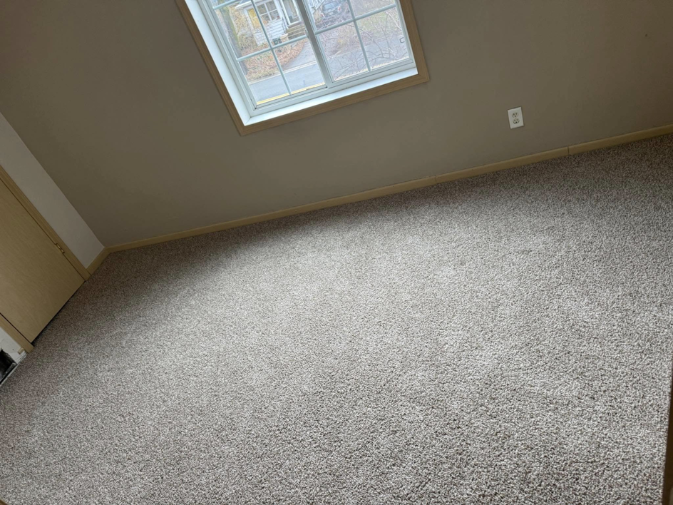 Finished grey carpet in a room with a window, installed by La 23 floors an more in Janesville, WI.