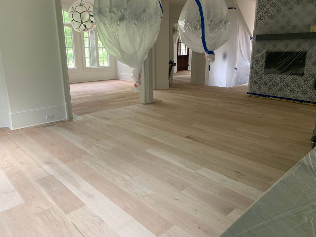 A beautifully finished light hardwood floor in a spacious living room, completed by Peach Design Inc. in Atlanta, GA.