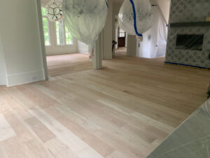 A beautifully finished light hardwood floor in a spacious living room, completed by Peach Design Inc. in Atlanta, GA.