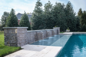 A beautiful finished swimming pool featuring a stone waterfall by Top Tier Pools in Franklin, TN.