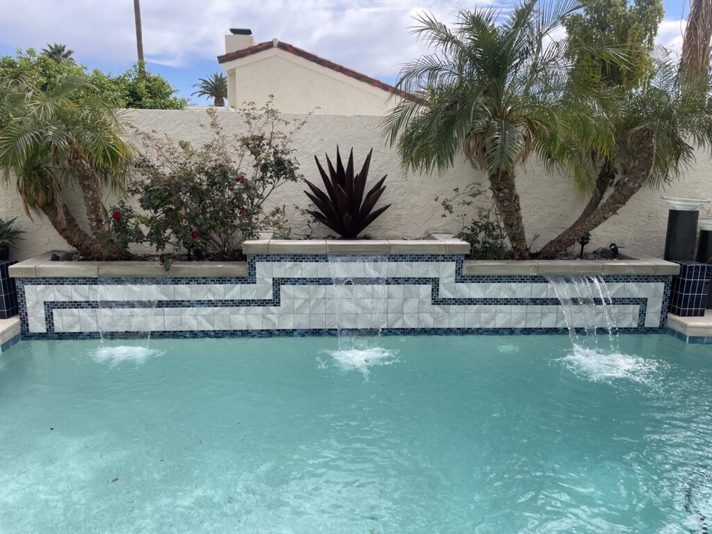 A beautifully finished swimming pool featuring decorative tiling and cascading waterfalls by All Valley Pools in Avondale, AZ.