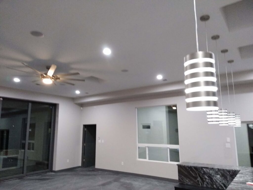 A finished room showcasing new recessed lighting, a modern ceiling fan, and pendant lights installed by The Specialist Electrical Contractor in Albuquerque, NM.