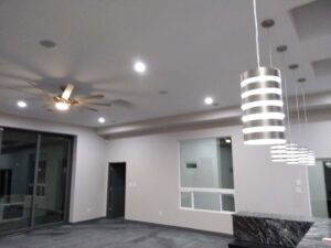 A finished room showcasing new recessed lighting, a modern ceiling fan, and pendant lights installed by The Specialist Electrical Contractor in Albuquerque, NM.