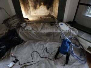 A fireplace area prepared with a drop cloth for cleaning by Delta Clean Air in Boston, MA