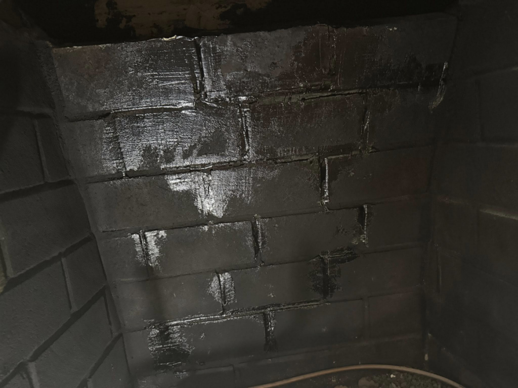 Close-up of a fireplace interior with newly coated and repaired brickwork by Chimney Care experts in Doraville, GA.