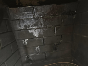 Close-up of a fireplace interior with newly coated and repaired brickwork by Chimney Care experts in Doraville, GA.