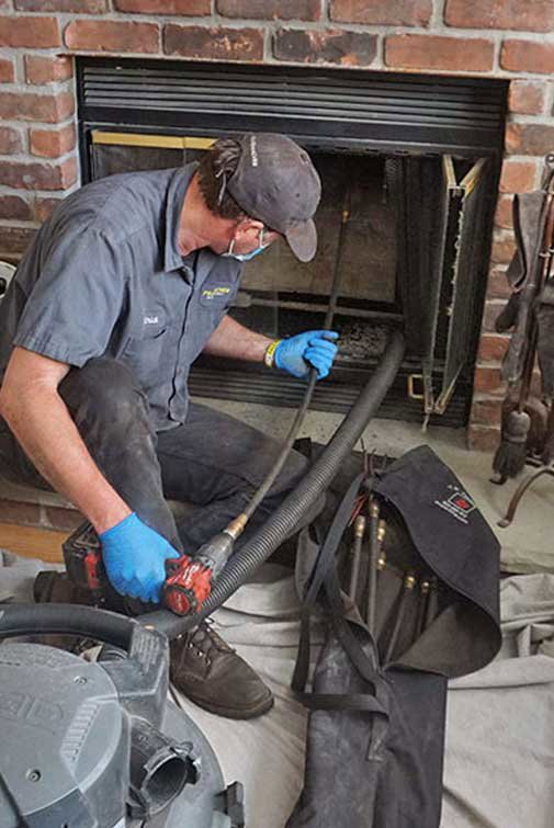 An 832 Home Service professional performing a fireplace and chimney cleaning service in Houston, TX.