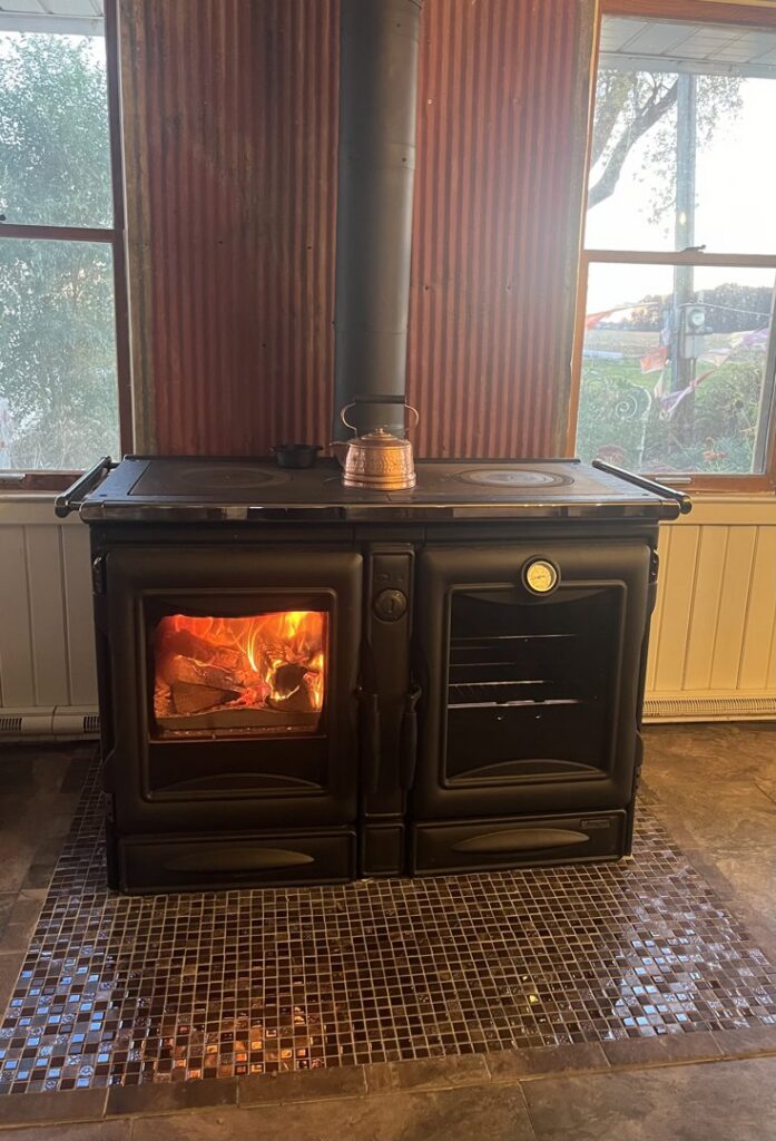 A warm fire burning safely in a fireplace behind a protective screen, serviced by Chimney Mechanix of Indiana in Lafayette, IN.