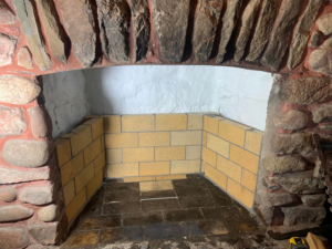 A fireplace firebox being rebuilt with new firebricks by The Chimney Sweep in Stafford, VA.
