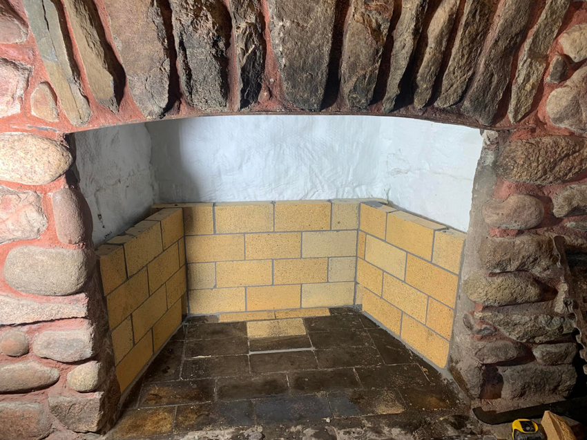 A fireplace firebox being rebuilt with new firebricks by The Chimney Sweep in Stafford, VA.