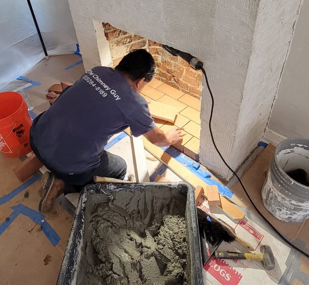 A worker from The Chimney Guy tiling the hearth of a fireplace during an installation in Los Angeles, CA.