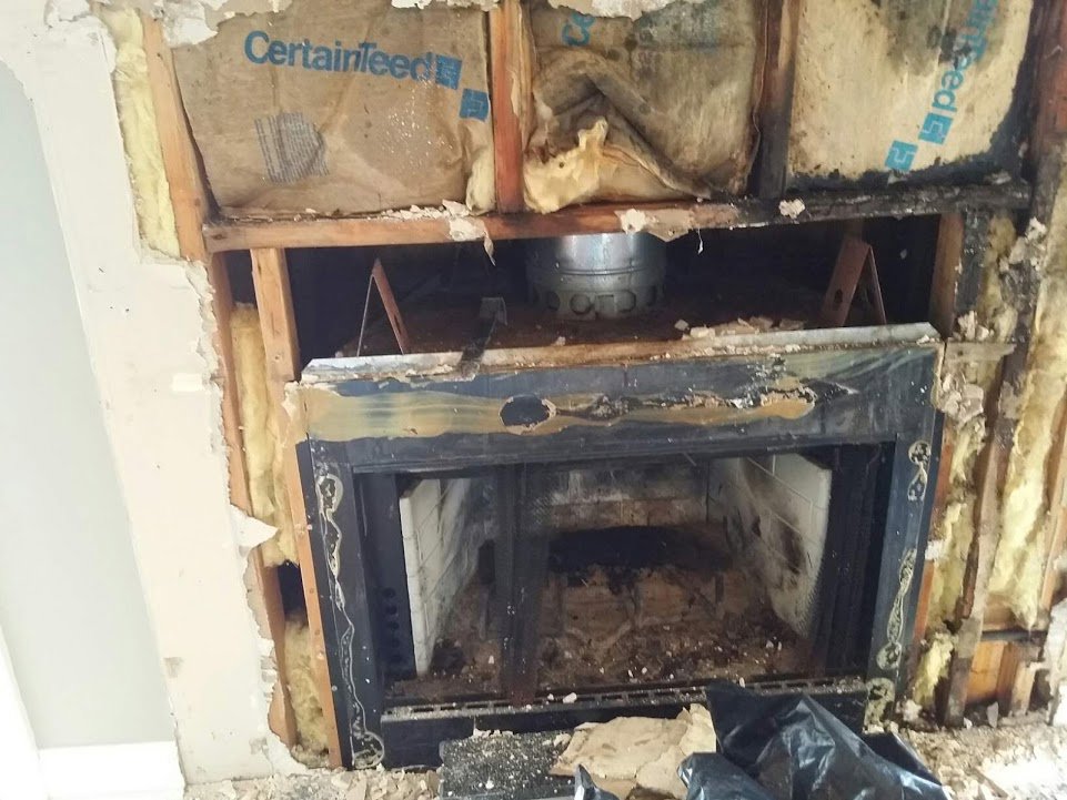 A fireplace being removed or installed, showing exposed framing and insulation, by Chip's Chimney in Rapid City, SD