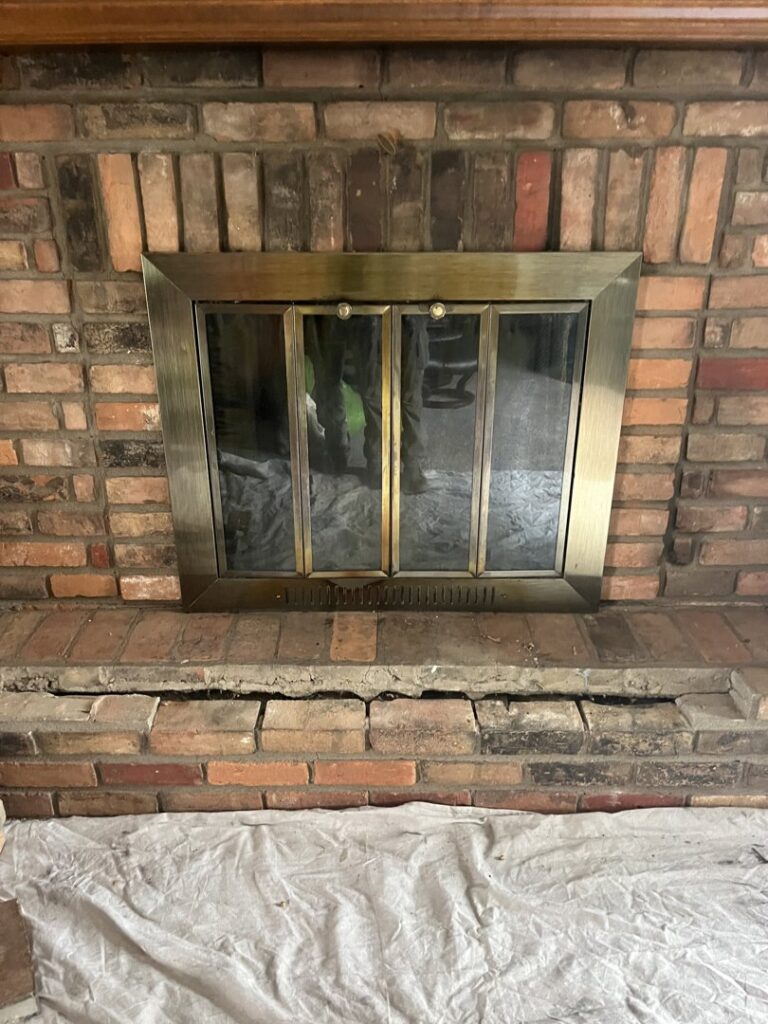 Indoor fireplace with a protective tarp on the floor, indicating preparation for a chimney service by Royal Chimney's in Blue Ash, OH.