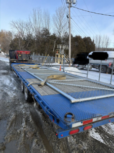A flatbed trailer transporting fence panels and metal tubing for a project by Wayside Fences in Brattleboro, VT.