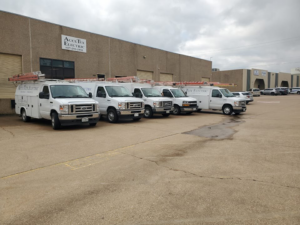 A fleet of white service vans for AccuTex Electric, ready for electrician jobs in Fort Worth, TX.